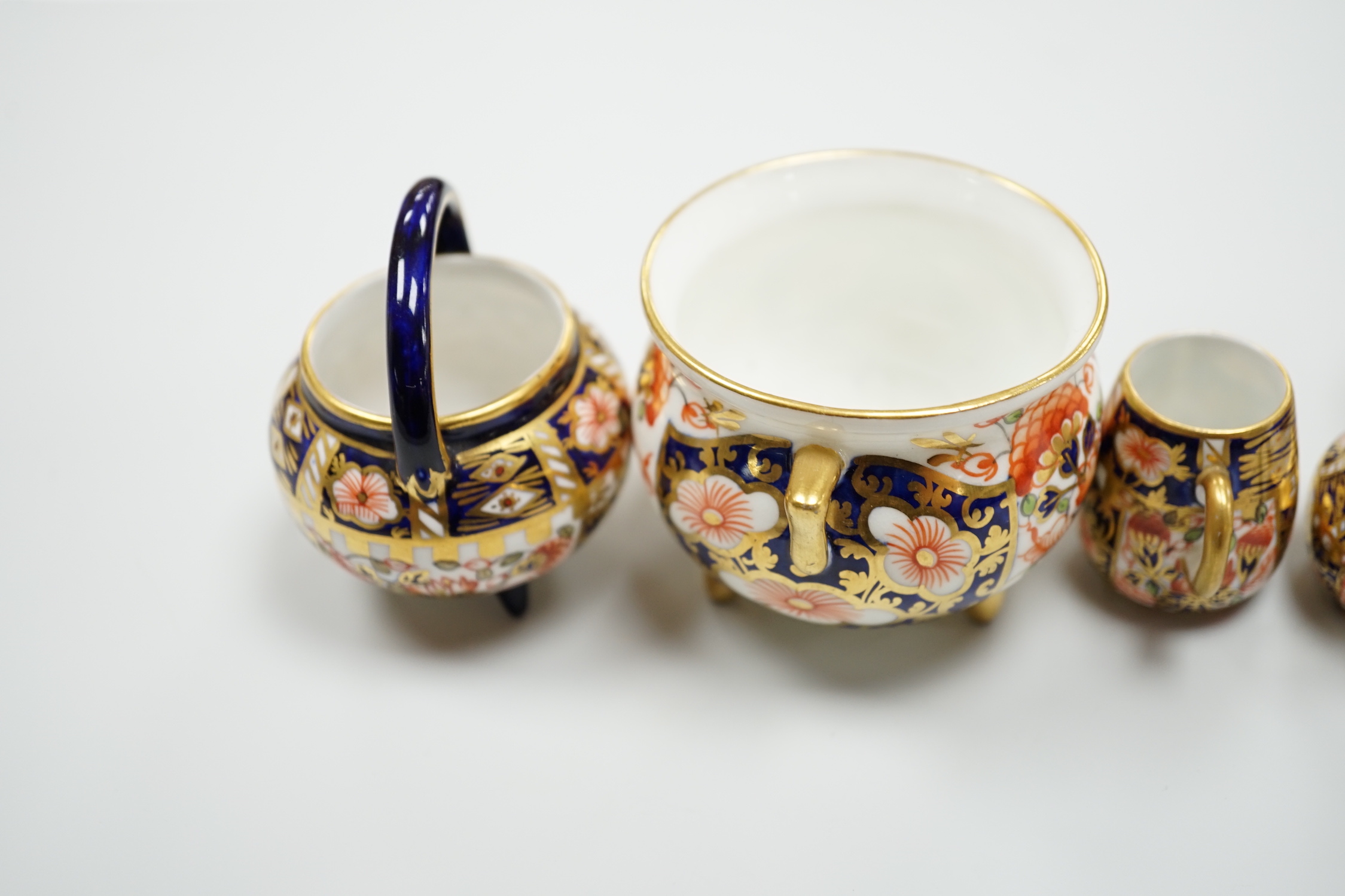 20th century Derby miniature wares in Imari patterns including a mug, a sauceboat, a cauldron, a large cauldron and a spoon warmer